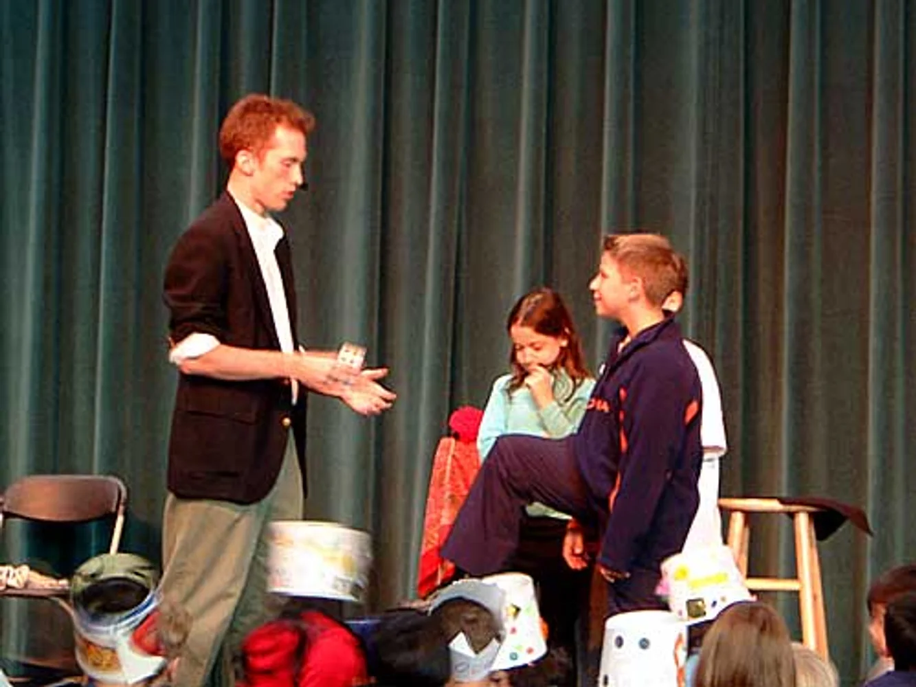 Jacob explaining a card trick to young volunteers