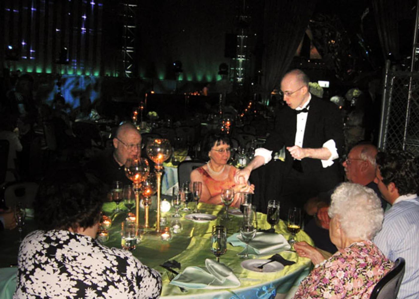 Jacob performing close-up magic at a formal dinner table