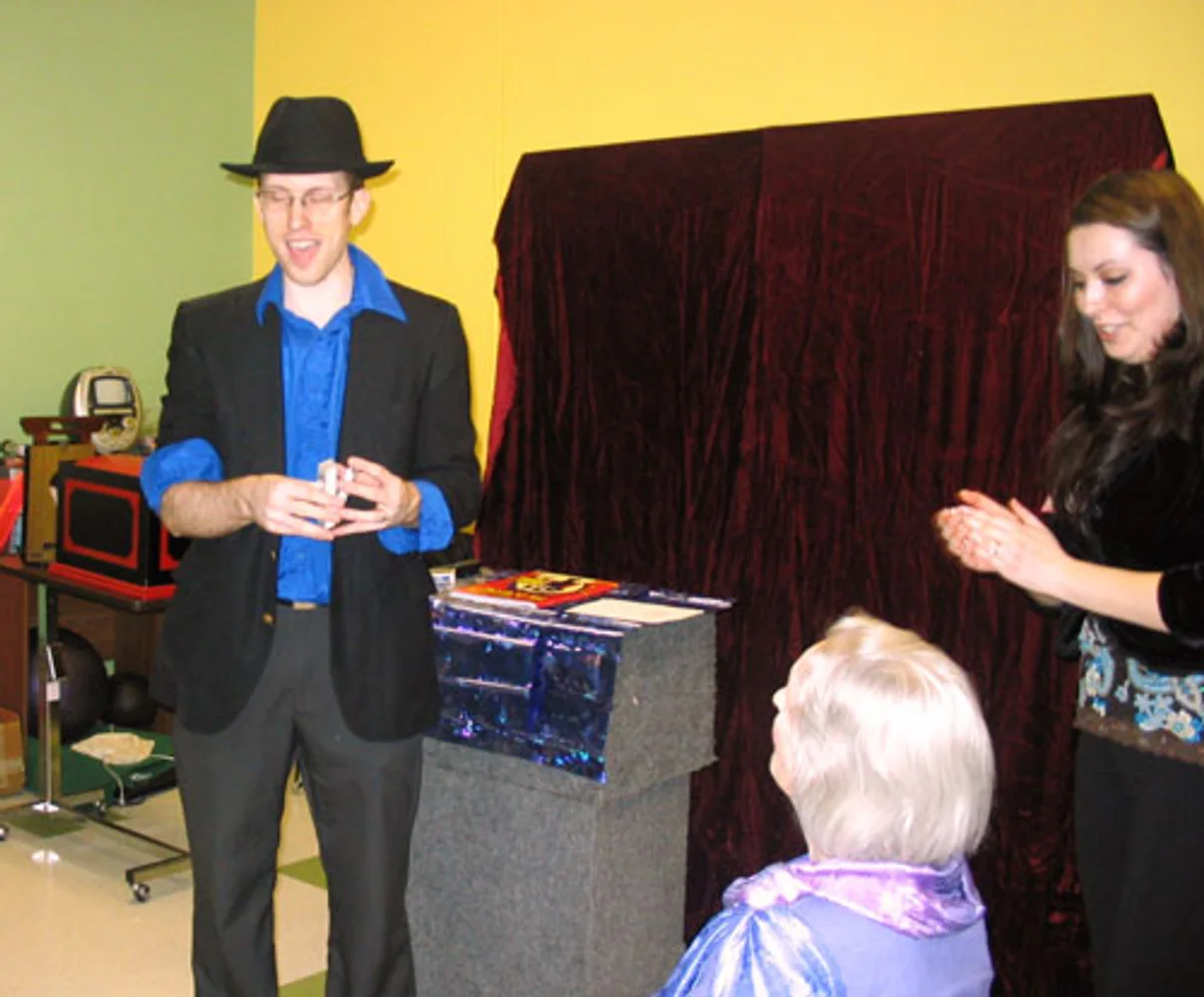 Jacob and Marti performing interactive magic with a volunteer